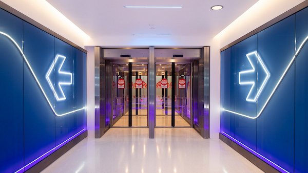 Illuminated arrow wayfinding walls inside Ontario International Airport, built by CALTEC as part of the terminal work.
